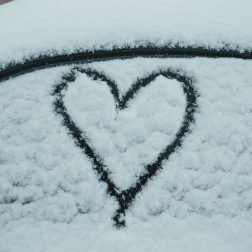 Lumisen auton ikkunassa piirretty sydän.