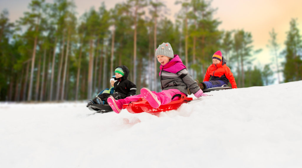 Lapsia laskemassa mäkeä pulkilla laskiaisena.